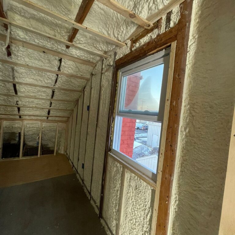 Fiberglass batts being installed in wall frame of New England home